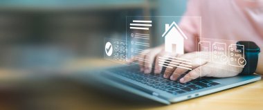 Akıllı ev arayüzü ve dijital mülkiyet belgeleriyle dizüstü bilgisayarda yazan elleri kapatın. Gayrimenkul teknolojisi, çevrimiçi mortgage başvurusu ve dijital mülk yönetimi kavramı.