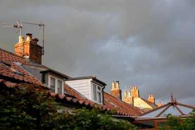 Çatılar ve karanlık bulutlu bir gökyüzü 