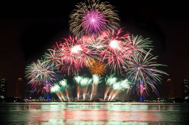 Kutlama gecesinde inanılmaz güzel renkli havai fişek gösterisi, deniz sahilinde su üzerinde çok renkli yansımalarla gösteriliyor. 