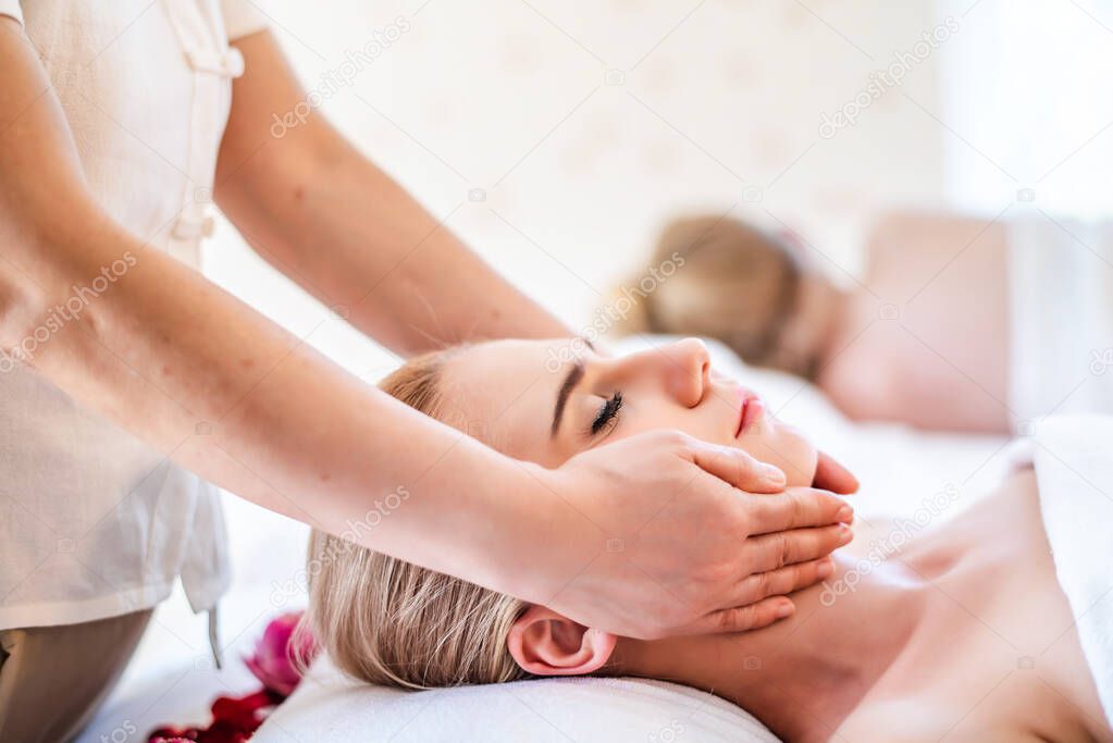 Beautiful young attractive Caucasian woman having body massage by Thai Masseur in spa salon. Beauty treatment and body care lifestyle concept 