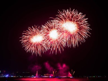 Kutlama gecesinde inanılmaz güzel renkli havai fişek gösterisi, deniz sahilinde su üzerinde çok renkli yansımalarla gösteriliyor. 