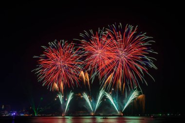 Kutlama gecesinde inanılmaz güzel renkli havai fişek gösterisi, deniz sahilinde su üzerinde çok renkli yansımalarla gösteriliyor. 