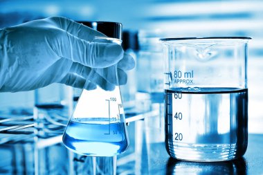 Laboratuvar geçmişi, bilim laboratuarı araştırma ve geliştirme konsepti ve laboratuvar malzemeleriyle dolu bir matarayı tutan bilim adamının eli.