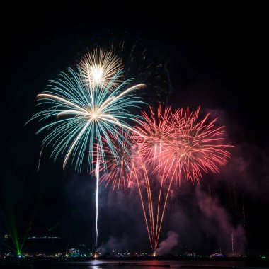 Kutlama gecesinde inanılmaz güzel renkli havai fişek gösterisi, deniz sahilinde su üzerinde çok renkli yansımalarla gösteriliyor. 