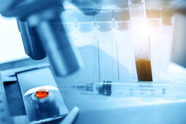 Laboratuvar teknisyeni mikroskopla test tüpündeki kan örneğini inceliyor. Tıbbi, farmasötik ve bilimsel araştırma ve geliştirme kavramı. 
