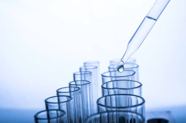 Beyaz arka plan, laboratuvar araştırma ve geliştirme konsepti üzerinde test tüpü için kimyasal sıvı veya temel yağ bırakılıyor.