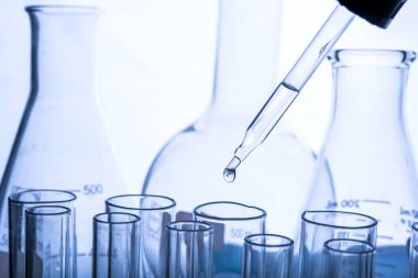 Beyaz arka plan, laboratuvar araştırma ve geliştirme konsepti üzerinde test tüpü için kimyasal sıvı veya temel yağ bırakılıyor.