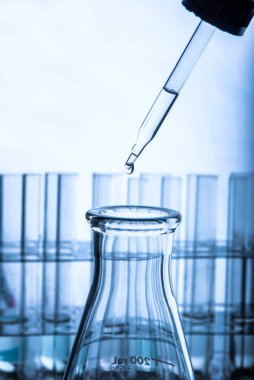 Beyaz arka plan, laboratuvar araştırma ve geliştirme konsepti üzerinde test tüpü için kimyasal sıvı veya temel yağ bırakılıyor.