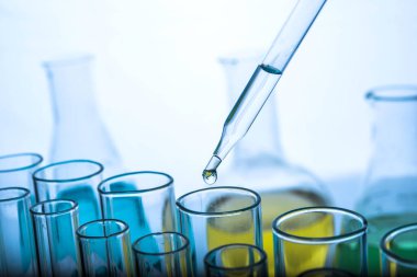 Beyaz arka plan, laboratuvar araştırma ve geliştirme konsepti üzerinde test tüpü için kimyasal sıvı veya temel yağ bırakılıyor.