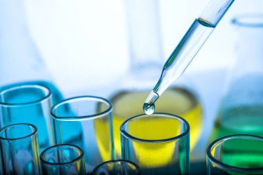 Beyaz arka plan, laboratuvar araştırma ve geliştirme konsepti üzerinde test tüpü için kimyasal sıvı veya temel yağ bırakılıyor.