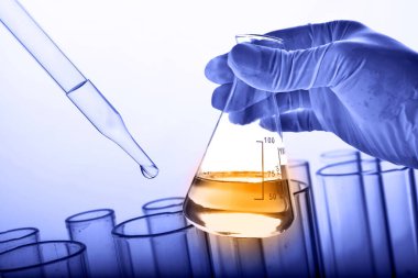 Laboratuvar geçmişi, bilim laboratuarı araştırma ve geliştirme konsepti ve laboratuvar malzemeleriyle dolu bir matarayı tutan bilim adamının eli. 