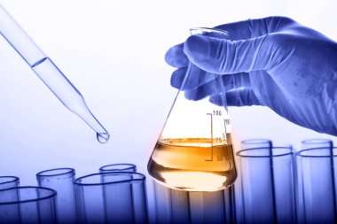 Laboratuvar geçmişi, bilim laboratuarı araştırma ve geliştirme konsepti ve laboratuvar malzemeleriyle dolu bir matarayı tutan bilim adamının eli. 