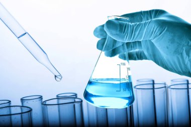 Laboratuvar geçmişi, bilim laboratuarı araştırma ve geliştirme konsepti ve laboratuvar malzemeleriyle dolu bir matarayı tutan bilim adamının eli. 