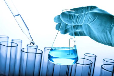 Laboratuvar geçmişi, bilim laboratuarı araştırma ve geliştirme konsepti ve laboratuvar malzemeleriyle dolu bir matarayı tutan bilim adamının eli. 