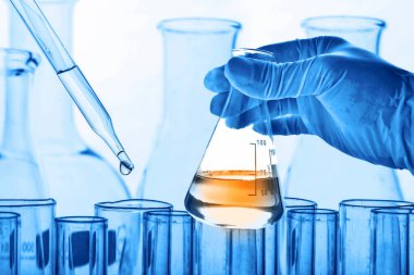 Laboratuvar geçmişi, bilim laboratuarı araştırma ve geliştirme konsepti ve laboratuvar malzemeleriyle dolu bir matarayı tutan bilim adamının eli. 