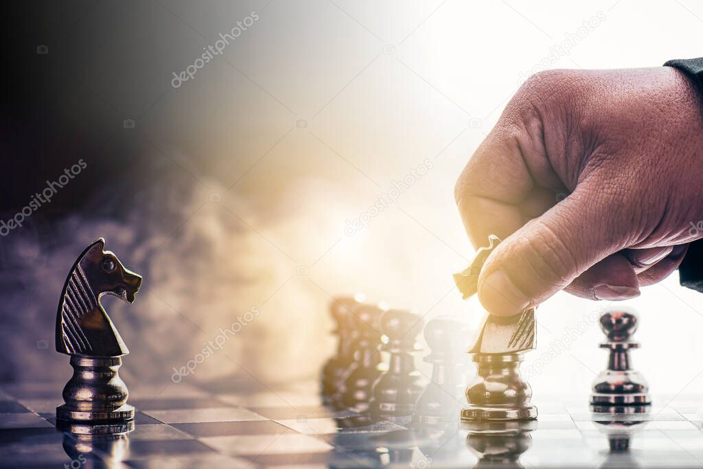 Businessman moving chess piece on chess board game concept for ideas and competition and strategy, business success concept, business competition planing teamwork strategic concept. 