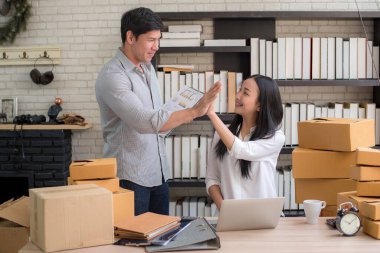 İnternetten alışveriş yapan mutlu Asyalı erkek ve kadın. 