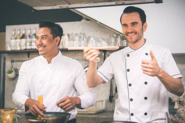 İki şef bir restoranın mutfağında yemek hazırlıyor. 