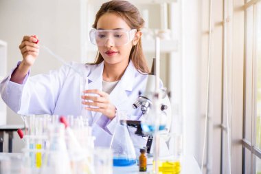 Çekici mutluluk bilimadamı kadın laboratuvar teknisyeni laboratuvar asistanı laboratuarda test tüpünde numune analiz ediyor. Tıbbi, farmasötik ve bilimsel araştırma ve geliştirme kavramı. 