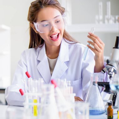 Çekici mutluluk bilimadamı kadın laboratuvar teknisyeni laboratuvar asistanı laboratuarda test tüpünde numune analiz ediyor. Tıbbi, farmasötik ve bilimsel araştırma ve geliştirme kavramı. 