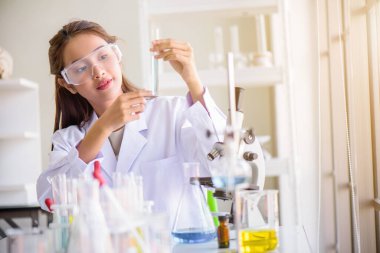 Çekici mutluluk bilimadamı kadın laboratuvar teknisyeni laboratuvar asistanı laboratuarda test tüpünde numune analiz ediyor. Tıbbi, farmasötik ve bilimsel araştırma ve geliştirme kavramı. 