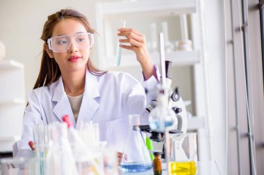 Laboratuvarda laboratuvar camlarıyla mikroskop testi yapan çekici mutluluk bilimci kadın. Bilim veya tıbbi araştırma ve geliştirme yeni antivirüs veya Covid-19 aşı konsepti. 