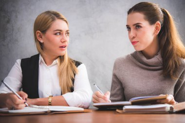 Kütüphanede birlikte çalışan ya da okuyan iki güzel kadın. 