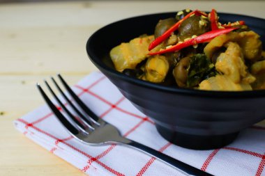 Tayland yemeği, kırmızı köri, domuz eti ve siyah kasede tütsülenmiş top. Yemek!