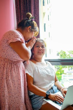 Laptop ve cep telefonu kullanan iki çalışan kadın. Modern iş hayatı