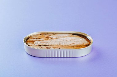 Mor arkaplanda konserve uskumru filetosu.