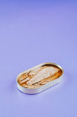 Mor arkaplanda konserve uskumru filetosu.