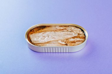 Mor arkaplanda konserve uskumru filetosu.