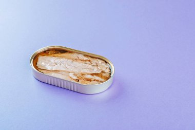 Mor arkaplanda konserve uskumru filetosu.