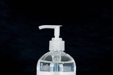 white liquid soap dispenser on a black background.