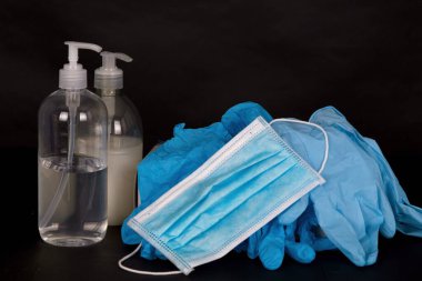 medical mask and protective gloves on a black background