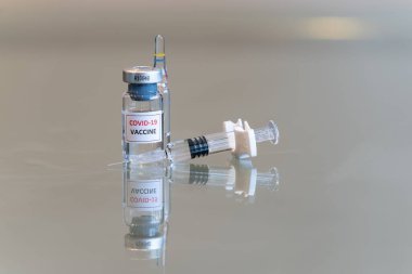 COVID 19 Coronvavirus aşısı şişesi. Önünde şırınga, sağında iğne ucu var. 093.