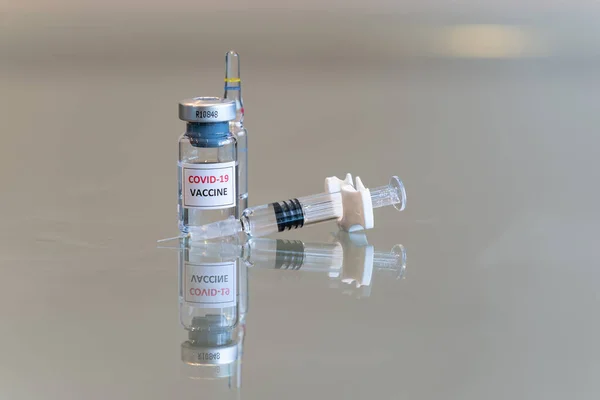 COVID 19 Coronvavirus aşısı şişesi. Önünde şırınga, sağında iğne ucu var. 093.
