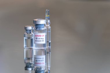 COVID-19 Coronavirus olarak etiketlenmiş tıbbi şişelerin yakından görüntüsü. Canlı Coronavirus virüsü. Biyolojik tehlike aşısı.