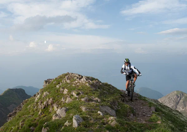 Mountainbike uphill on mountain ridge — Stock Photo, Image