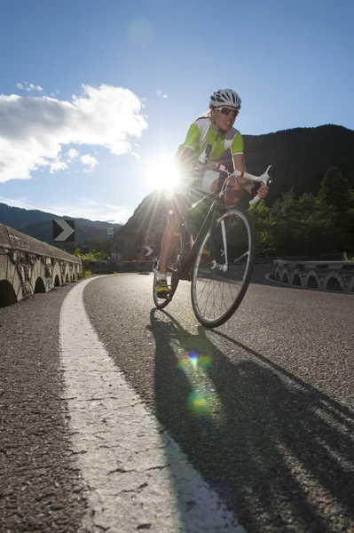 Girl by sunset downhill cycling — Stock Photo, Image