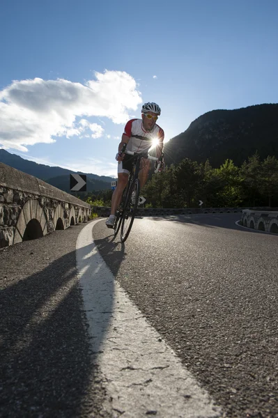 Road cycling downhill by sunset — Stock Photo, Image