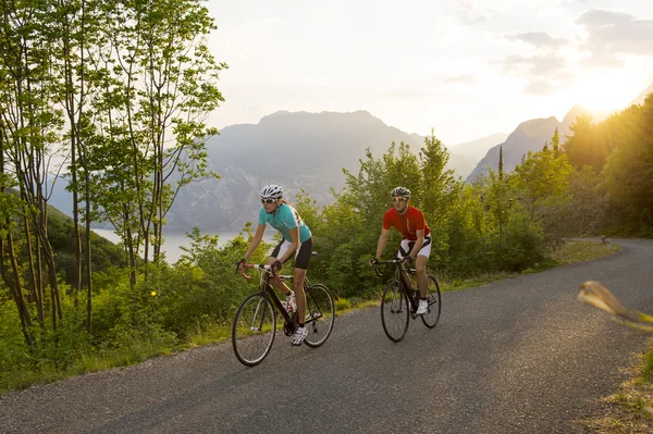 Cyklist cykla i bakom solnedgången — Stockfoto