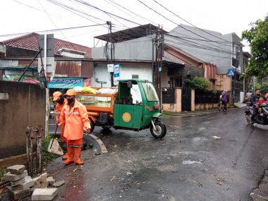 Editoryal Kullanım için, 20 Şubat 2021, PPSU (penanganan prasarana dan sarana umum), Doğu Jakarta, Endonezya 'da sel baskınında küçük bir nehirde turuncu üniforma kullanan iki temizlikçi
