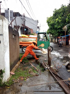 Editoryal Kullanım için, 20 Şubat 2021, PPSU (penanganan prasarana dan sarana umum), Doğu Jakarta, Endonezya 'da sel baskınında küçük bir nehirde turuncu üniforma kullanan iki temizlikçi