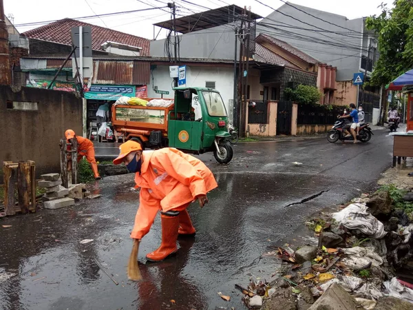 Editoryal Kullanım için, 20 Şubat 2021, PPSU (penanganan prasarana dan sarana umum), Doğu Jakarta, Endonezya 'da sel baskınında küçük bir nehirde turuncu üniforma kullanan iki temizlikçi