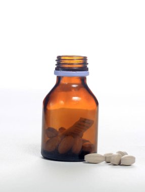 Beyaz arkaplanda şişe vitaminini dök