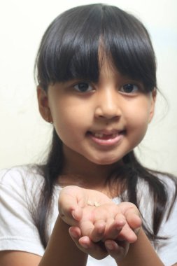 İçerideki fotoğraf stüdyosu, gevşek dişlerini gösteren kız.