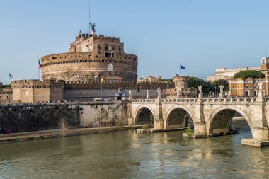 Arka planda Sant 'Angelo Kalesi ve mavi gökyüzü olan Tevere Nehri.