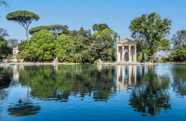 Villa Borghese parkındaki suya yansıyan ağaçlarla dolu küçük bir göl.