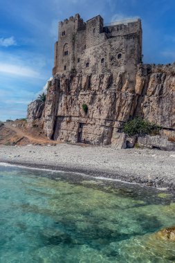Roseto Capo Spulico plajı. Üzerinde turkuaz su ve bir kale var.